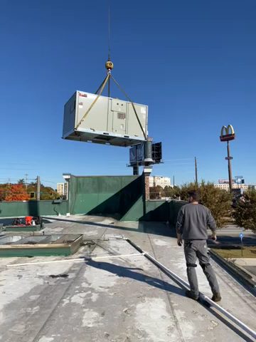 Rooftop HVAC unit being set by crane